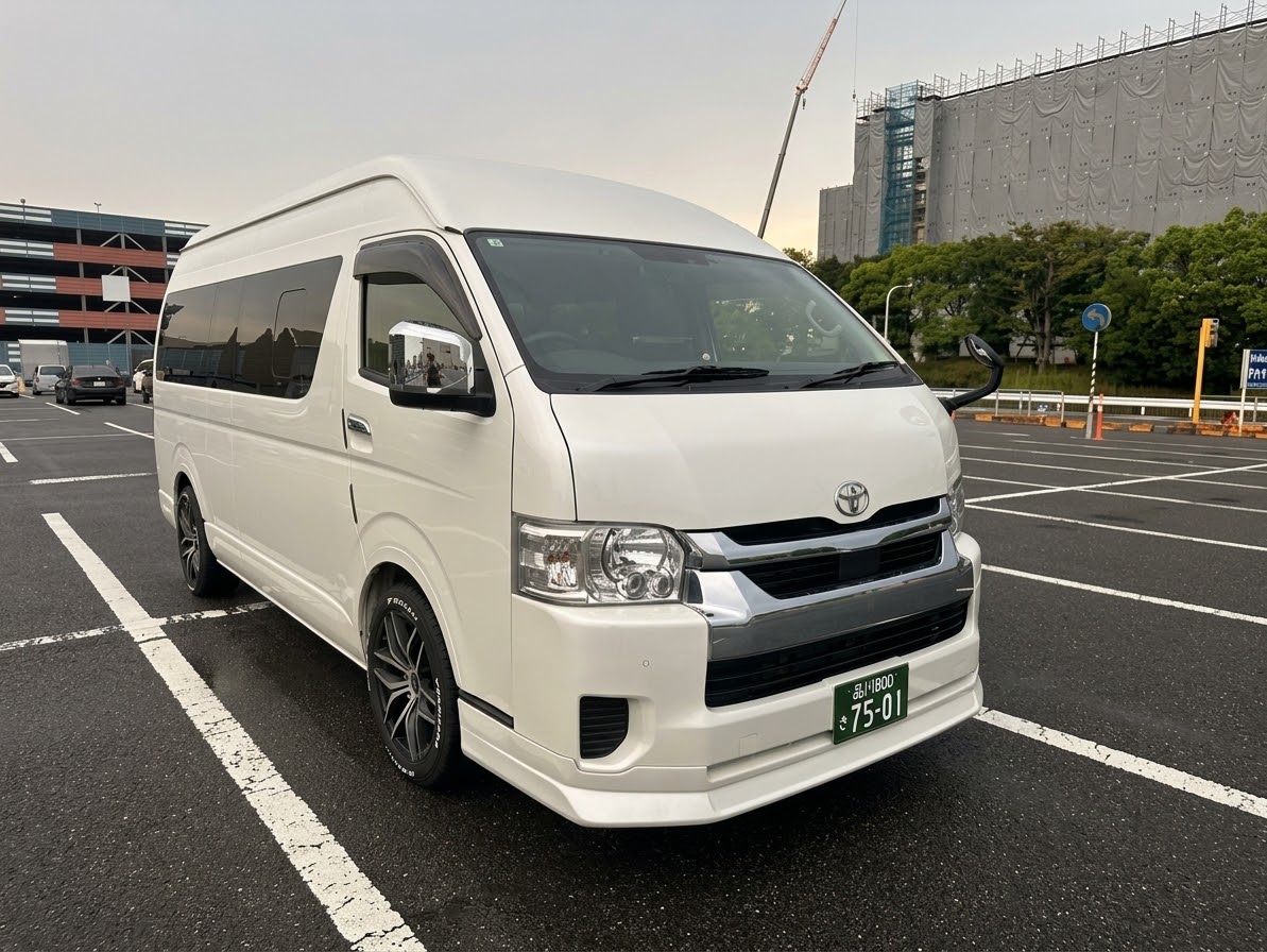 White Toyota Hiace high-roof passenger van with Japanese commercial green license plate